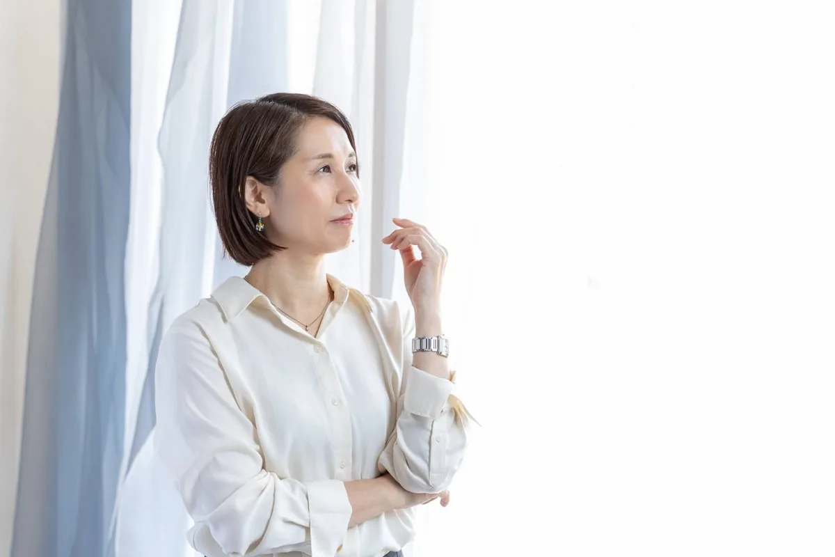 明るい窓辺に立つ吉村祐子